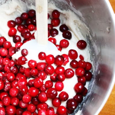 This fresh cranberry cake is beautiful and delicious, a unique dessert to serve during the holidays. Don't skimp on the hot butter sauce: it's the best part!