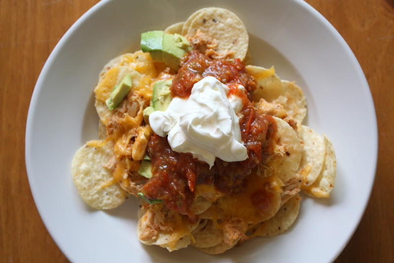 These nachos are topped with yummy shredded chicken, melted cheese, and all your favorite nacho toppings. And they're made in the oven!