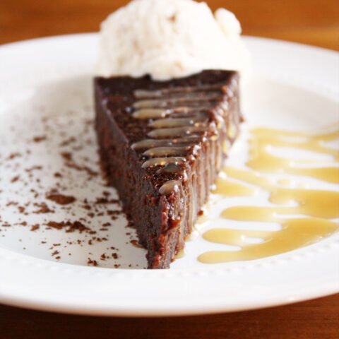 flourless chocolate cake with salted caramel drizzle and whipped cream