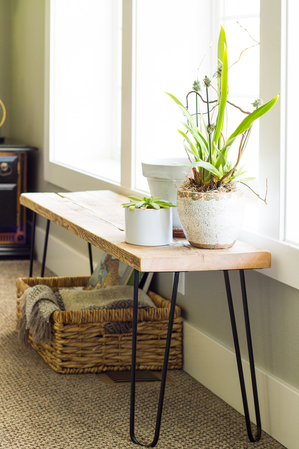 Our naturalist living room makeover included building this simple bench from hair pin legs and a leftover slab of reclaimed wood.