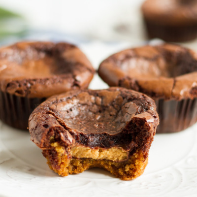 These may look like unassuming brownies baked in cupcake tins, but once you unwrap them, you'll see they have a peanut butter cookie base! And even better, there's a peanut butter cup hidden in the middle!