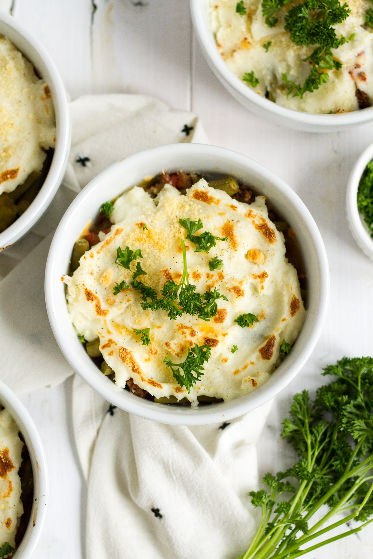 Shepherd's pie is one of my family's favorite easy dinners. These individual italian-style shepherd's pies have a delicious filling with herbs and tomatoes, and a sprinkling of parmesan cheese on top.