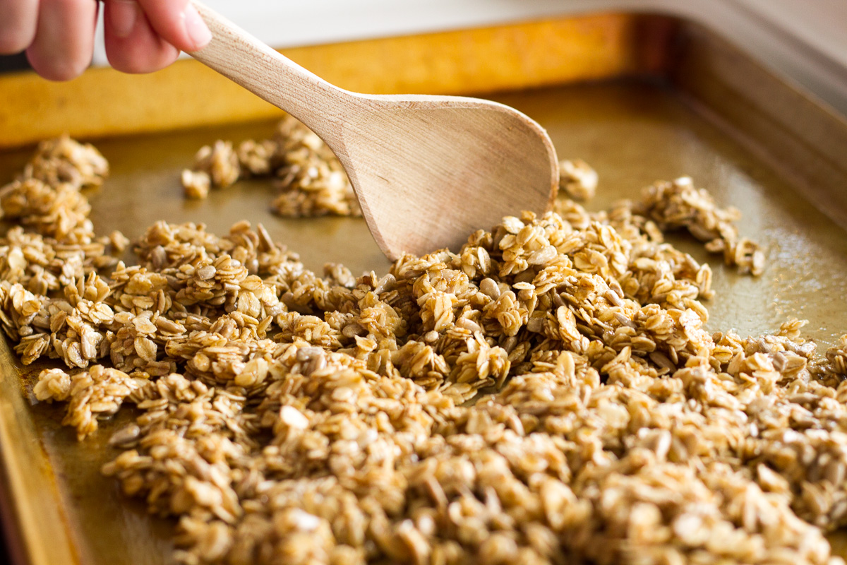 Crunchy homemade tropical granola with oats, sunflower seeds, macadamia nuts, coconut chips, dried tropical fruits likes pineapple, mango, and papaya, lightly sweetened with honey and brown sugar.