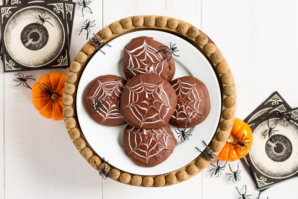 Deliciously cakey chocolate cookies dipped in a rich, homemade chocolate glaze and decorated with white icing spider webs. Perfect for Halloween!