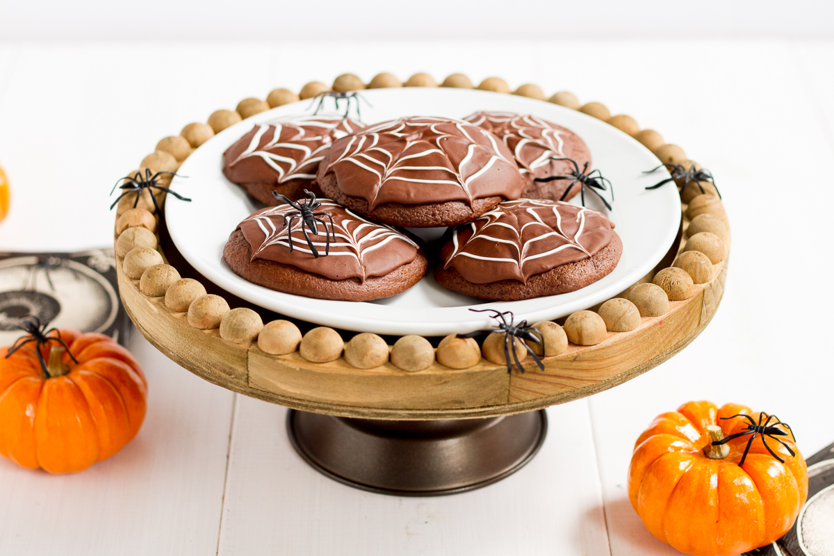 Deliciously cakey chocolate cookies dipped in a rich, homemade chocolate glaze and decorated with white icing spider webs. Perfect for Halloween!