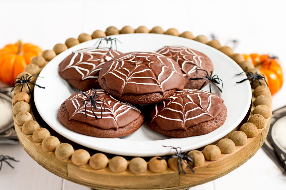 Deliciously cakey chocolate cookies dipped in a rich, homemade chocolate glaze and decorated with white icing spider webs. Perfect for Halloween!