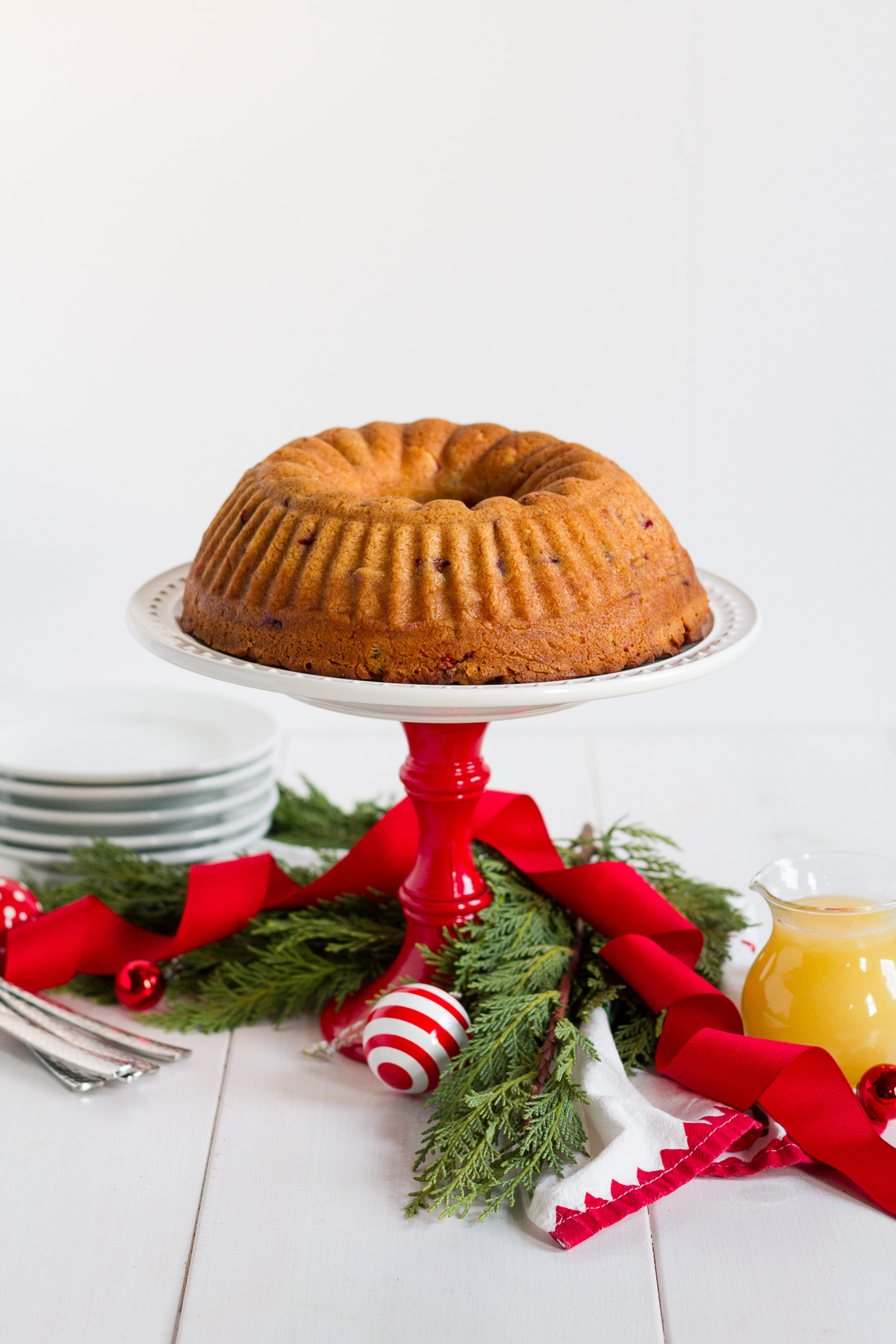 This fresh cranberry cake with hot butter sauce is simple and delicious. It is a breeze to make, but it looks beautiful and tastes luxurious. All of those things combine to make it the perfect dessert to serve to guests during the holidays.