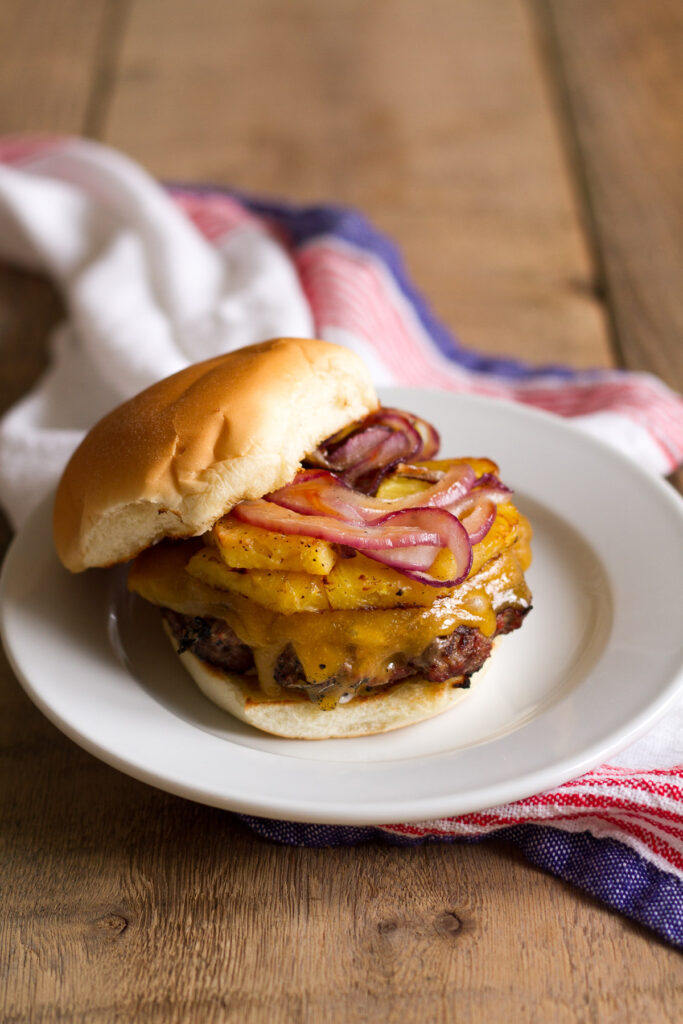 tropical bbq burgers with grilled pineapple, onions, and cheddar