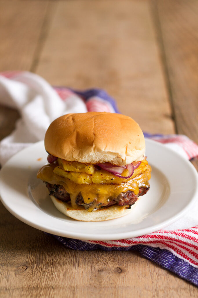 tropical bbq burgers with grilled pineapple, onions, and cheddar