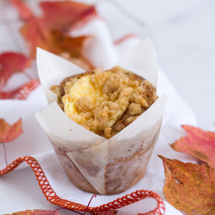 pumpkin cream cheese streusel muffin on a napkin with fall leaves