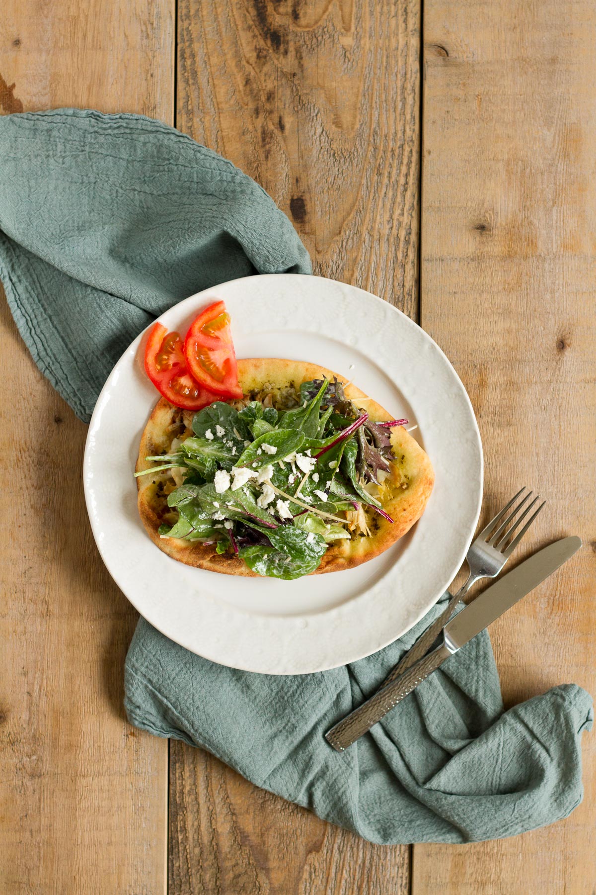 flatbread pizza topped with a fresh caesar salad